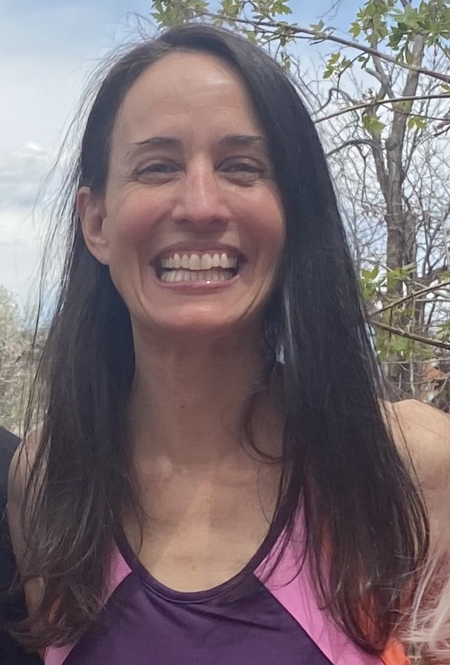 Stacey Phillips smiling softly outdoors in natural light